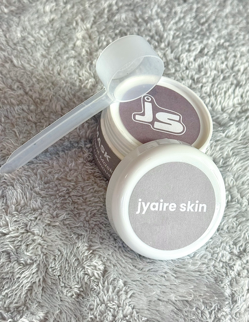 Jyaire Skin skincare product with applicator on a textured gray surface